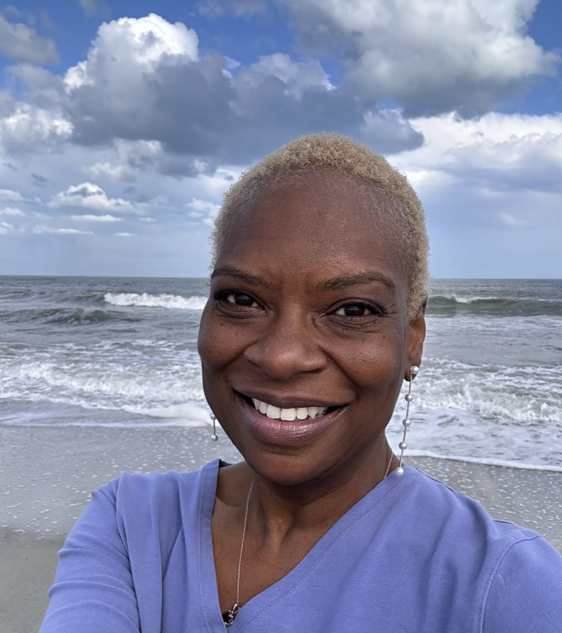 Rita Lynn Berry smiling at the ocean, representing compassionate therapy and healing for women in North Carolina.