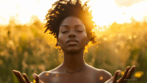 Woman standing with arms wide open under golden sky, embracing love and light.