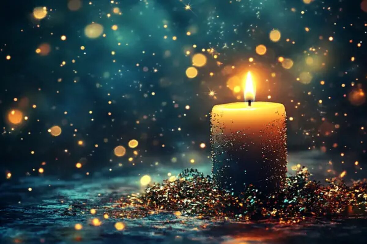 Lit candle glowing in the darkness, symbolizing Christ as the Light of the World on Christmas Eve.